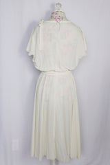 Women's vintage 1970's short sleeve capped sleeved midi length off white cream dress with draped neckline, attached tie bow on shoulder, elastic waistband, and detachable matching tie belt