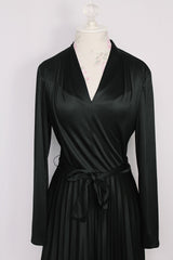Women's vintage 1970's Joan Curtis long sleeve midi length black dress with pleated accordion skirt, a V shaped neckline, and detachable matching tie belt.