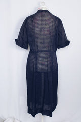 Women's vintage 1950's short sleeve midi length navy blue sheer shirt dress with subtle checkered print.