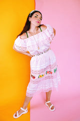 pale pink vintage off the shoulder midi length dress with embroidered flowers and lace and ribbon details