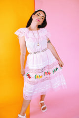 pale pink vintage off the shoulder midi length dress with embroidered flowers and lace and ribbon details