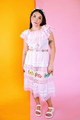 pale pink vintage off the shoulder midi length dress with embroidered flowers and lace and ribbon details