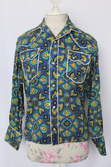 Women's vintage 1970's long sleeve button up western style blouse in all over blue print. White trim and pearl popper buttons.