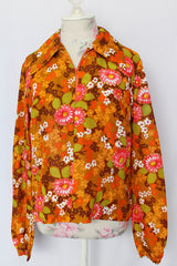 Women's vintage 1970's long sleeve floral printed blouse with half zipper closure and pointy dagger collar. Floral print is in shades of brown and orange
