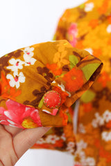 Women's vintage 1970's long sleeve floral printed blouse with half zipper closure and pointy dagger collar. Floral print is in shades of brown and orange