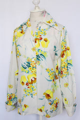 Women's vintage 1970's Hollywood Blouse by Praw, Made in California label long sleeve button up blouse with collar in white polyester with all over yellow and blue floral print.