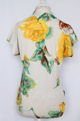 Women's vintage 1970's short sleeve white polyester blouse with all over yellow and green floral print.