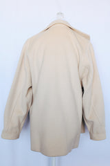 Women's vintage 1980's long sleeve short cream colored wool coat with a one button closure.