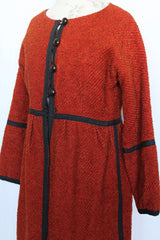 Women's vintage 1970's Fog Eater, Block Island, Tuscon label long sleeve orange textured half button closure jacket with black trim trim detail.