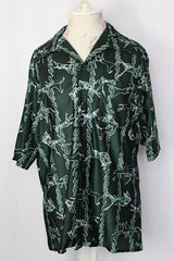 Women's or men's vintage 1970's short sleeve slinky polyester button up shirt with dagger collar and green all over horse and buffalo print.