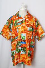 Men's or women's vintage 1970's Mauna Kea label short sleeve button up shirt with double lapel, left chest pocket, and amber buttons in orange all over Hawaiian print.