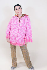 Women's vintage 1970's pink colored crochet knit poncho in soft acrylic material. Fringe trim hem and buttons up the front.