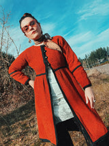 Women's vintage 1970's Fog Eater, Block Island, Tuscon label long sleeve orange textured half button closure jacket with black trim trim detail.