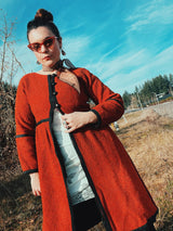 Women's vintage 1970's Fog Eater, Block Island, Tuscon label long sleeve orange textured half button closure jacket with black trim trim detail.