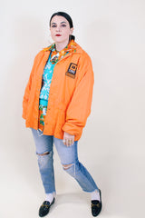 Men's or women's vintage 1970's Pla-Jac by Dunbrooke label long sleeve orange lightweight windbreaker with two patches on left chest.