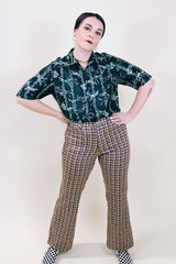 Women's or men's vintage 1970's short sleeve slinky polyester button up shirt with dagger collar and green all over horse and buffalo print.