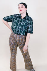 Women's or men's vintage 1970's short sleeve slinky polyester button up shirt with dagger collar and green all over horse and buffalo print.