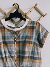 Women's vintage western style 1960's short sleeve midi length plaid print shift dress with white scalloped trim. Grey, teal, and mustard yellow colors.