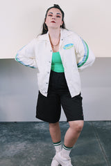 Men's or women's vintage 1970's Swingster, World of Wearables label long sleeve white nylon windbreaker with popper buttons, pockets, and collar. Cotton liner. Has green and blue stripes.