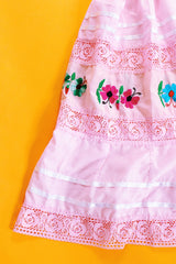 pale pink vintage off the shoulder midi length dress with embroidered flowers and lace and ribbon details