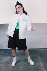 Men's or women's vintage 1970's Swingster, World of Wearables label long sleeve white nylon windbreaker with popper buttons, pockets, and collar. Cotton liner. Has green and blue stripes.