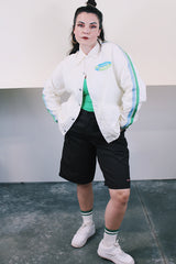 Men's or women's vintage 1970's Swingster, World of Wearables label long sleeve white nylon windbreaker with popper buttons, pockets, and collar. Cotton liner. Has green and blue stripes.