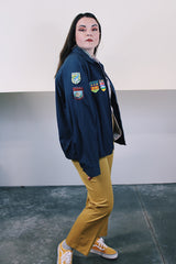 Men's vintage 1980's Lacy Sportswear label long sleeve zip up sportswear windbreaker jacket in navy blue cotton with patches sewn on all over.