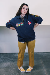 Men's vintage 1980's Lacy Sportswear label long sleeve zip up sportswear windbreaker jacket in navy blue cotton with patches sewn on all over.