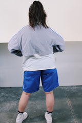 Women's or men's vintage 1980's Nike label long sleeve lightweight pullover windbreaker with a half zip closure in grey, white, and blue.