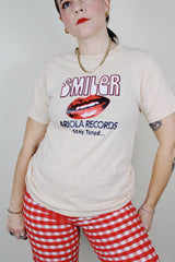 short sleeve light tan cotton t-shirt with Smiler Ariola Records graphic on the front 1970's