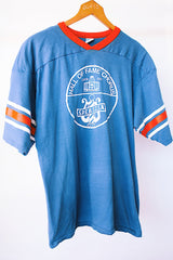 short sleeve blue t-shirt with red and white stripes on arm graphic on front and back vintage 1970's