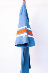 short sleeve blue t-shirt with red and white stripes on arm graphic on front and back vintage 1970's