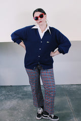 Men's or women's vintage 1980's IZOD Lacoste label long sleeve navy blue acrylic button up cardigan with ribbed hem and cuffs and V shaped neckline.