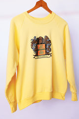 long sleeve yellow vintage crew neck sweater with emblem graphic on front