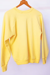 long sleeve yellow vintage crew neck sweater with emblem graphic on front