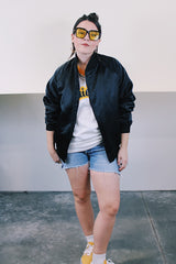 Women's or men's vintage 1988 long sleeve black shiny stain polyester bomber jacket with side pockets. Has 88' Olympics Seoul Korea embroidered on the back with Olympics logo.