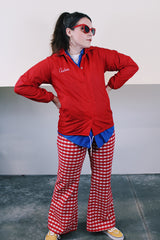 Women's vintage 1970's Pla-Jac by Dunbrooke, Made in USA label long sleeve red nylon windbreaker with popper buttons, cotton liner, round collar, and white graphic.