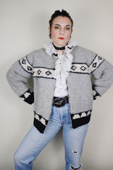 vintage 1970's long sleeve wool zip up cowichan cardigan in grey, white, and black with a deer design on the back