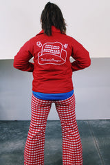 Women's vintage 1970's Pla-Jac by Dunbrooke, Made in USA label long sleeve red nylon windbreaker with popper buttons, cotton liner, round collar, and white graphic.