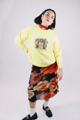 long sleeve yellow vintage crew neck sweater with emblem graphic on front