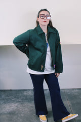 Women's or men's vintage 1980's Riverside Flexbac, Made in USA label long sleeve green zip up station jacket with patches all over. Has collar and pockets.