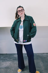 Women's or men's vintage 1980's Riverside Flexbac, Made in USA label long sleeve green zip up station jacket with patches all over. Has collar and pockets.