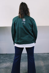 Women's or men's vintage 1980's Riverside Flexbac, Made in USA label long sleeve green zip up station jacket with patches all over. Has collar and pockets.