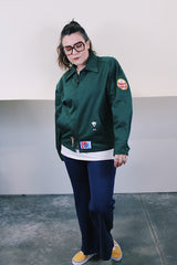 Women's or men's vintage 1980's Riverside Flexbac, Made in USA label long sleeve green zip up station jacket with patches all over. Has collar and pockets.