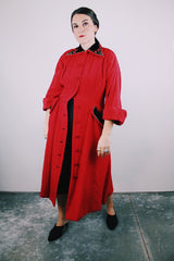 1950's red quilted duster coat with black velvet trim has pointy collar and buttons up the front