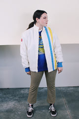 Men's or women's vintage 1970's long sleeve white nylon material zip up windbreaker jacket with a yellow and blue strip on one side. Has patches, pockets, and faux fur body liner.