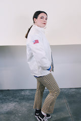 Men's or women's vintage 1970's long sleeve white nylon material zip up windbreaker jacket with a yellow and blue strip on one side. Has patches, pockets, and faux fur body liner.