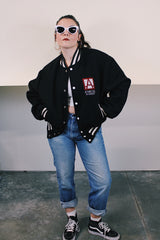 Men's vintage 1970's Empire Sporting Goods, New York, Union Made label long sleeve black wool bomber jacket with white popper buttons and white striped trim. 1979 Jethro Tull in Concert jacket.