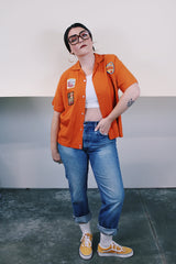 Men's vintage 1960's Joel's Striker short sleeve orange button up bowling shirt with three patches sewn on. Rayon acrylic blend material. One chest pocket and small collar.