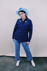 Women's vintage western style 1970's California Ranchwear label long sleeve navy blue blouse with pointy collar and pearly blue popper buttons. Has floral embroidery on shoulders.